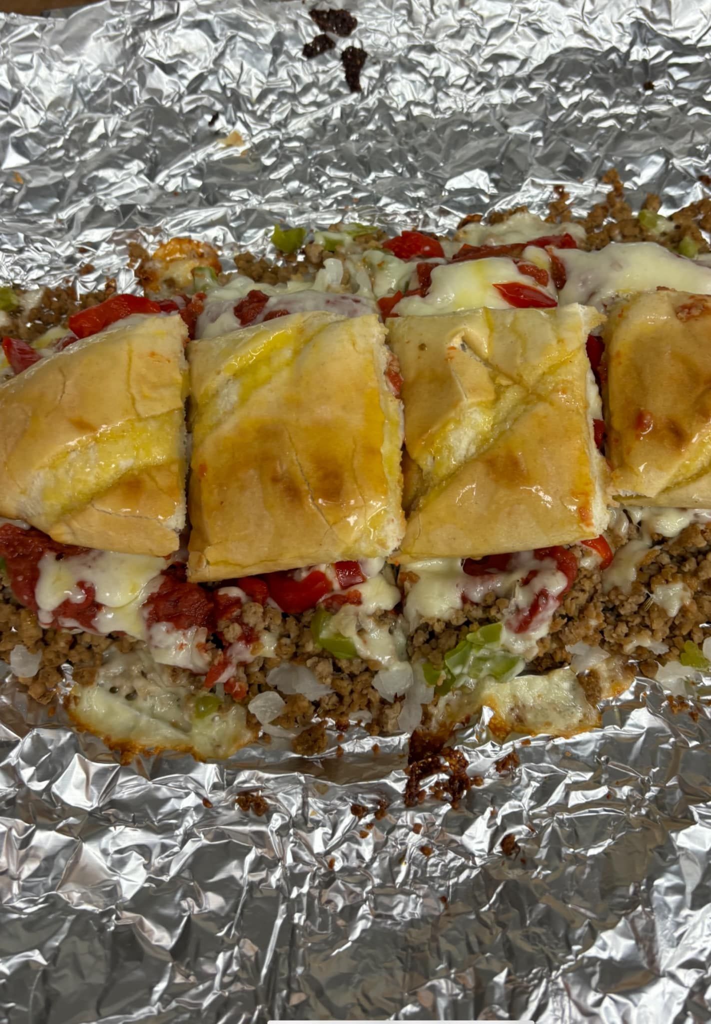 A close up of a stromboli sandwich on tin foil.