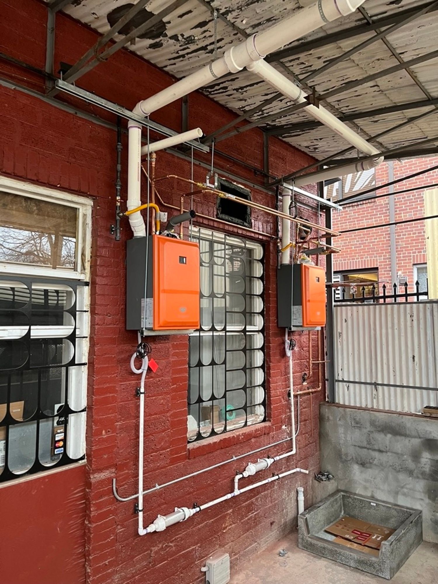 A brick building with a lot of pipes coming out of it.