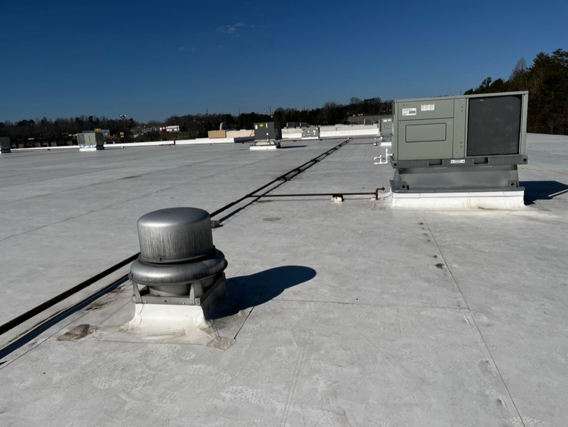 The roof of a building has a few air conditioners on it
