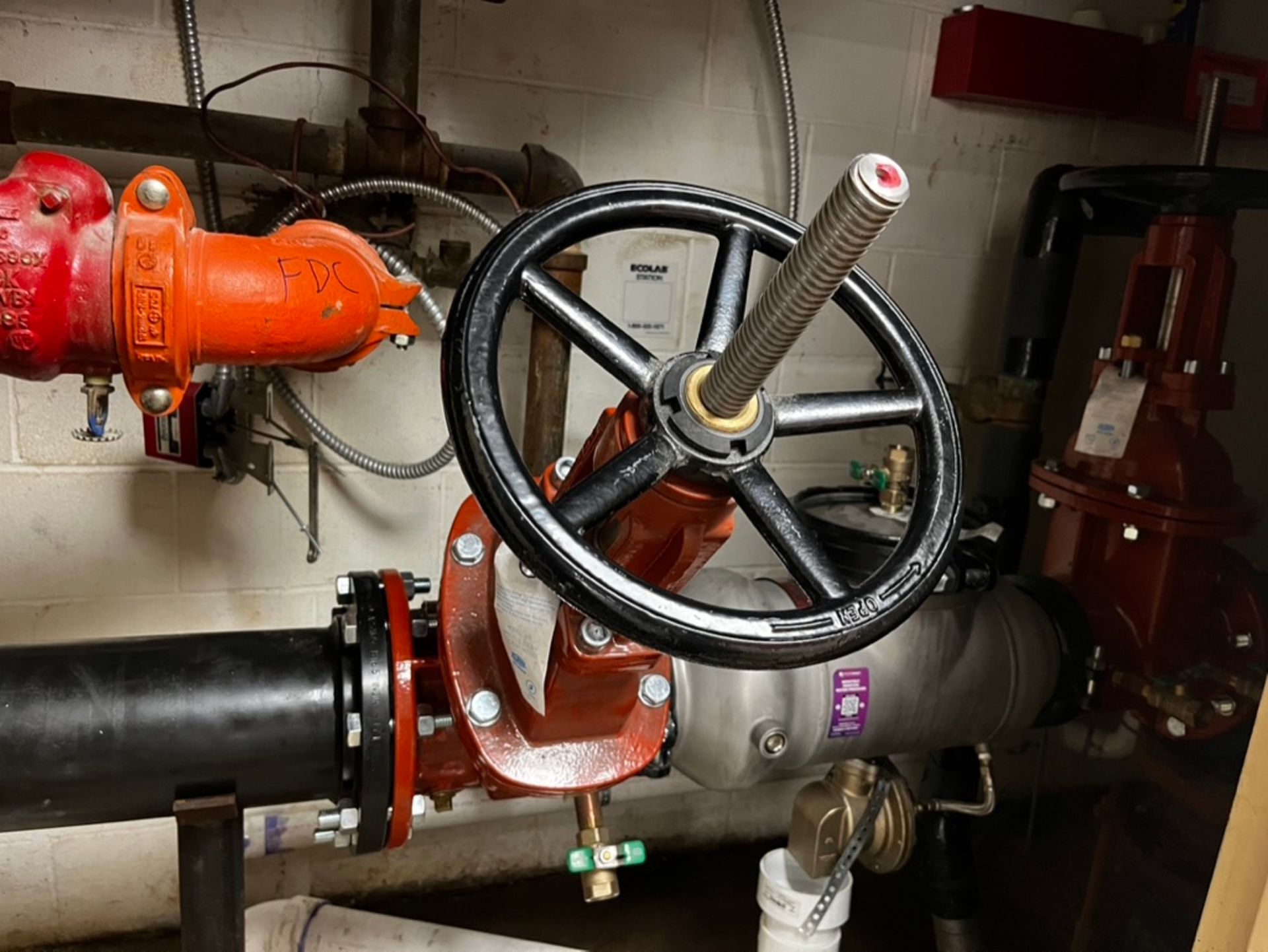A valve is sitting on top of a pipe in a room.