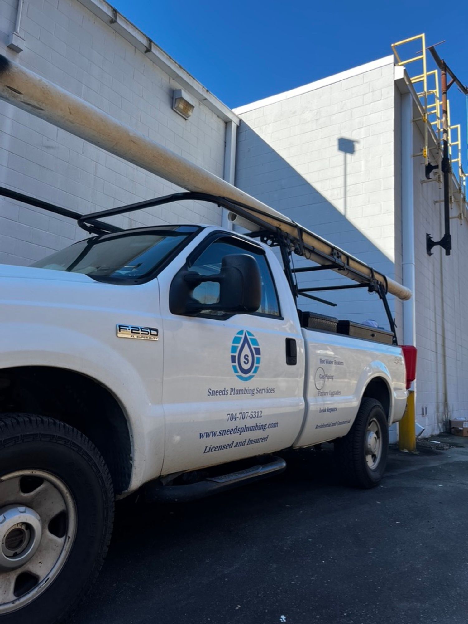 A white truck is parked in front of a building