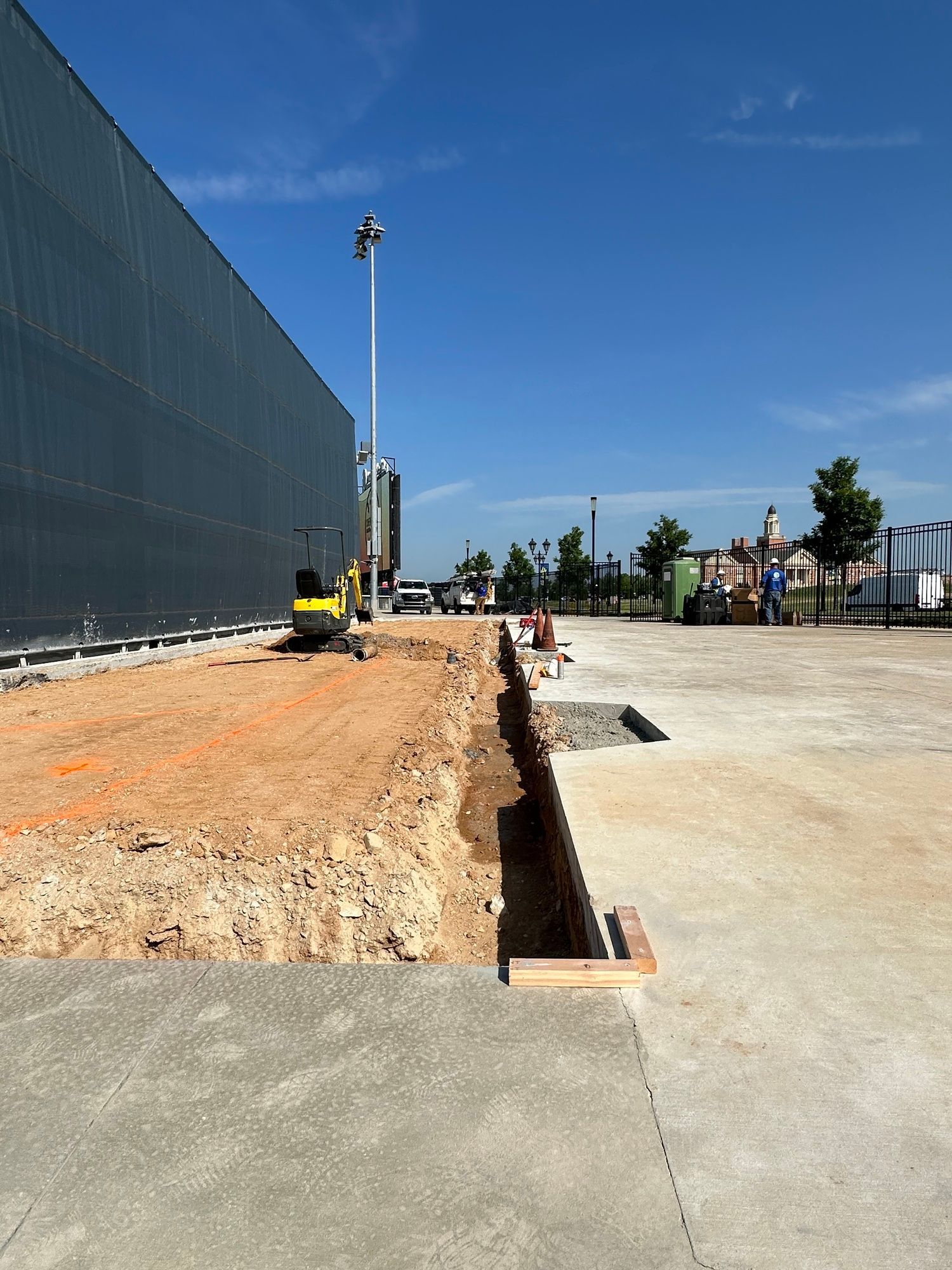 A construction site with a large building in the background.