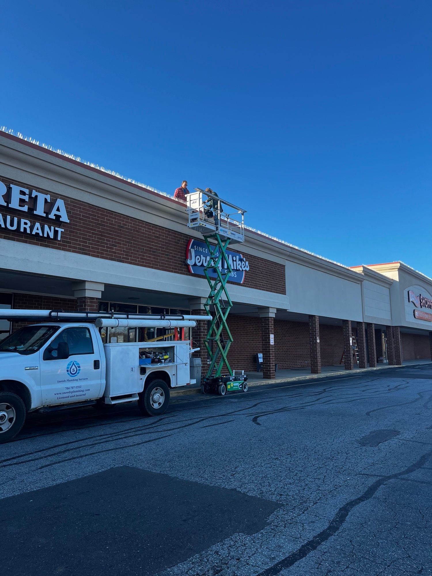A white truck is parked in front of a brick building.