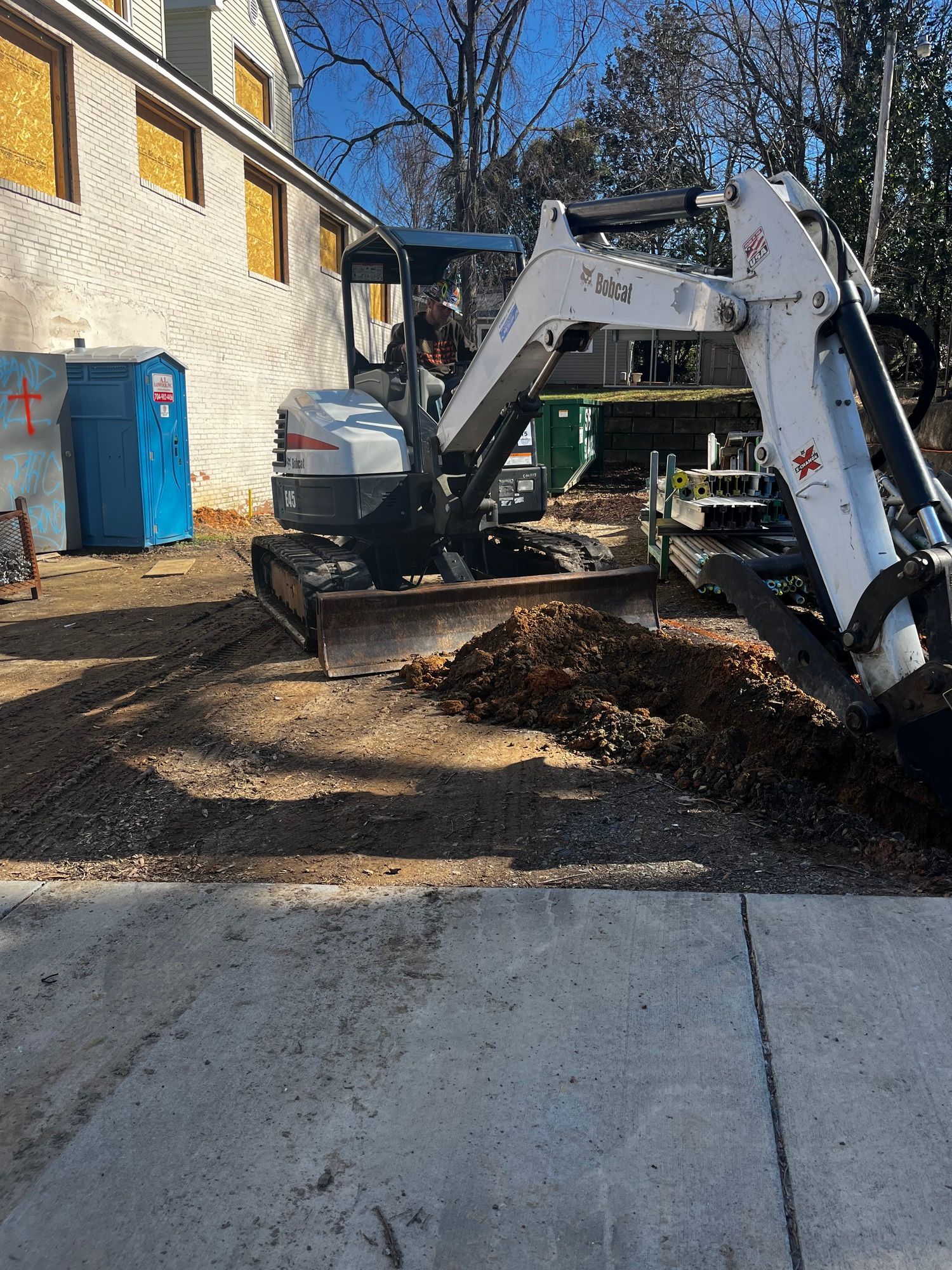 A bulldozer is digging a hole in the ground in front of a building.