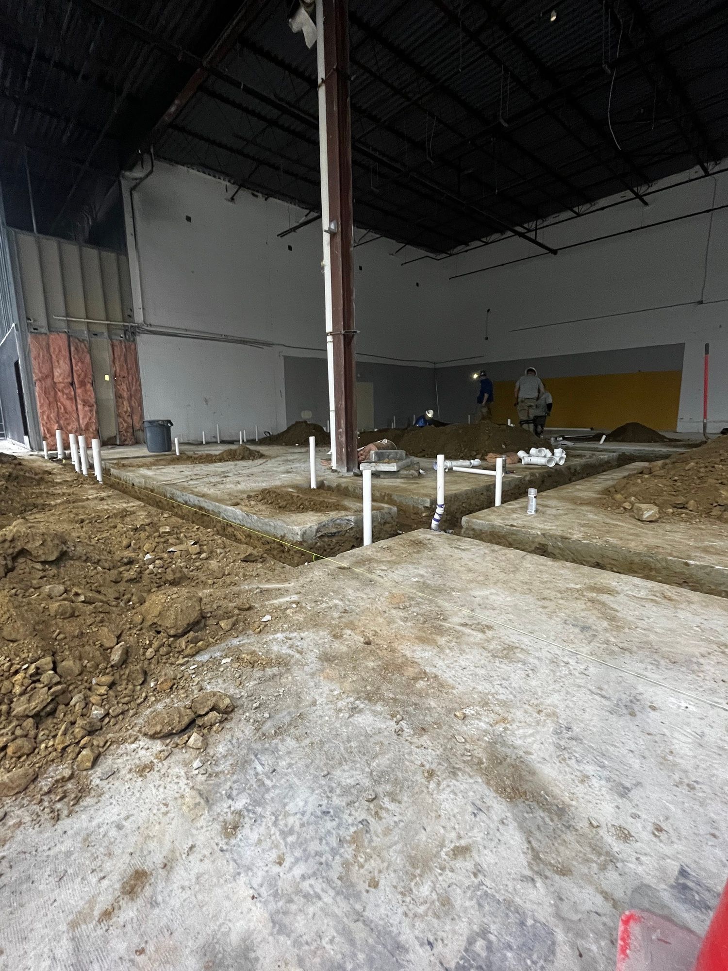 A large building under construction with a lot of dirt on the floor.