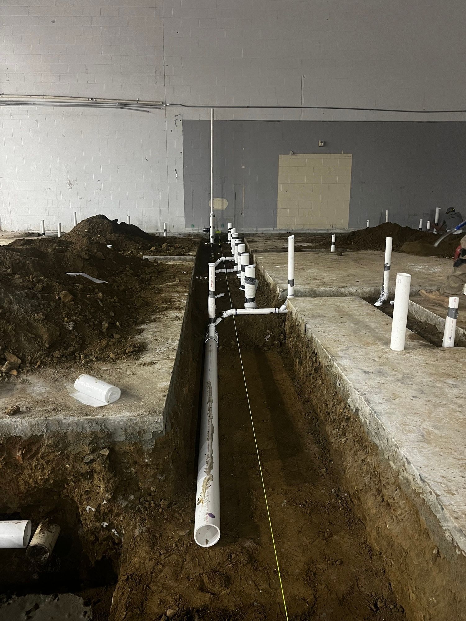 A row of pipes are being installed in a hole in the ground.