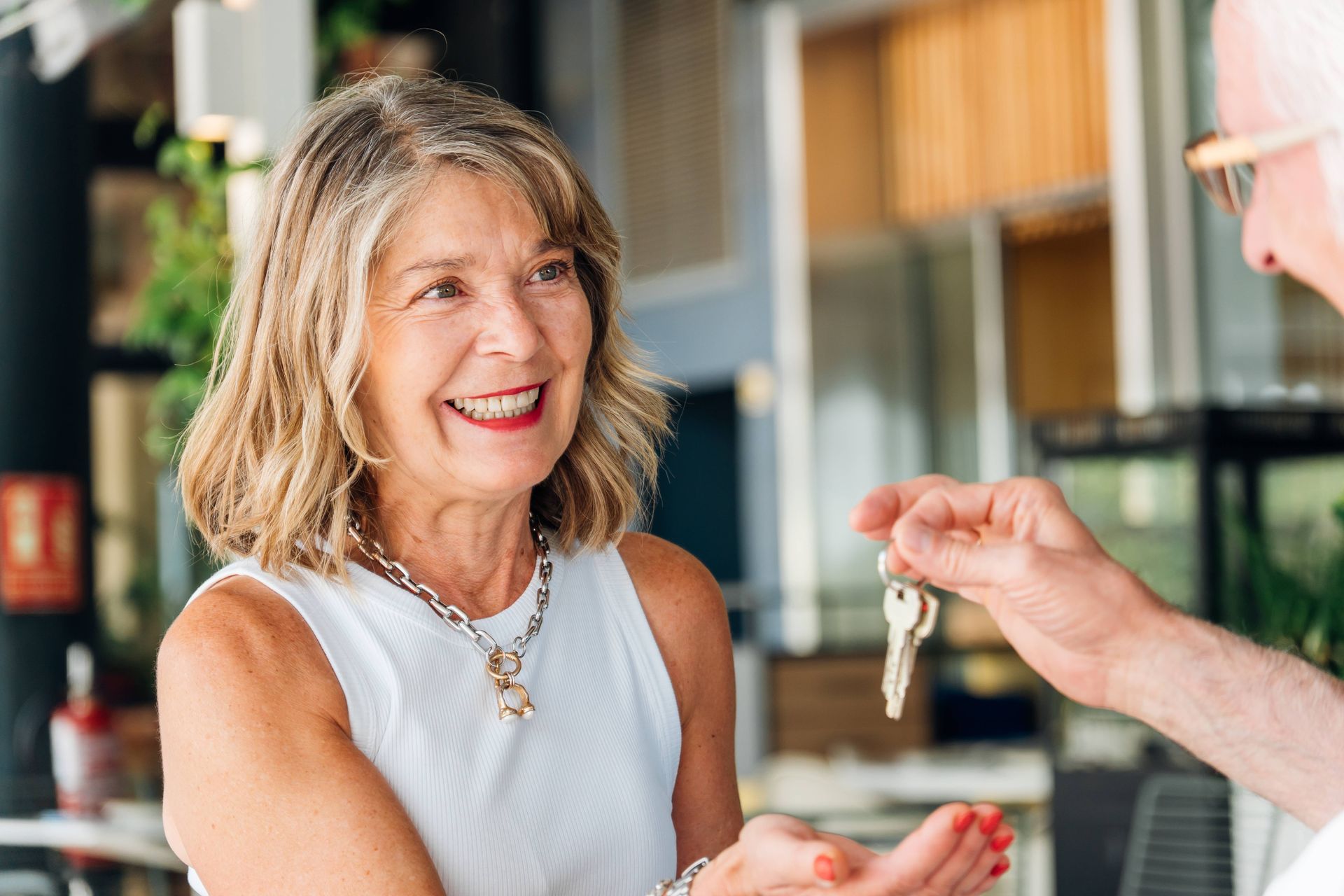 A senior woman accepting property keys after a move to independent living with Cincinnati seniors