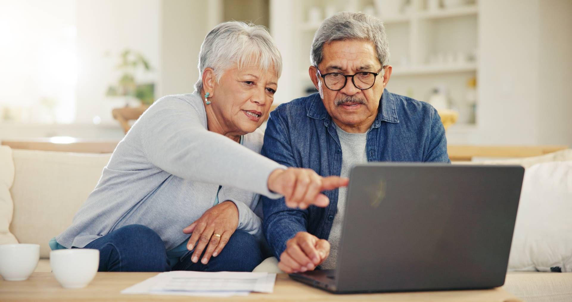 Older couple browsing senior living floor plans on a laptop