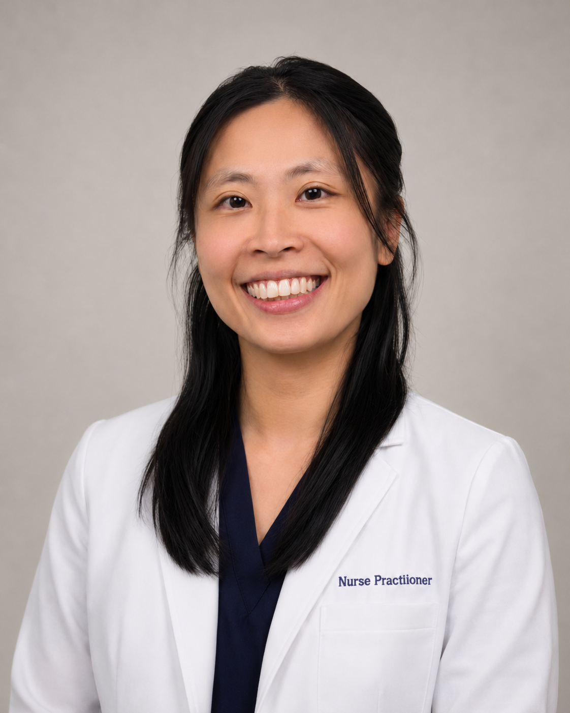 Smiling doctor in a white coat against a gray studio background