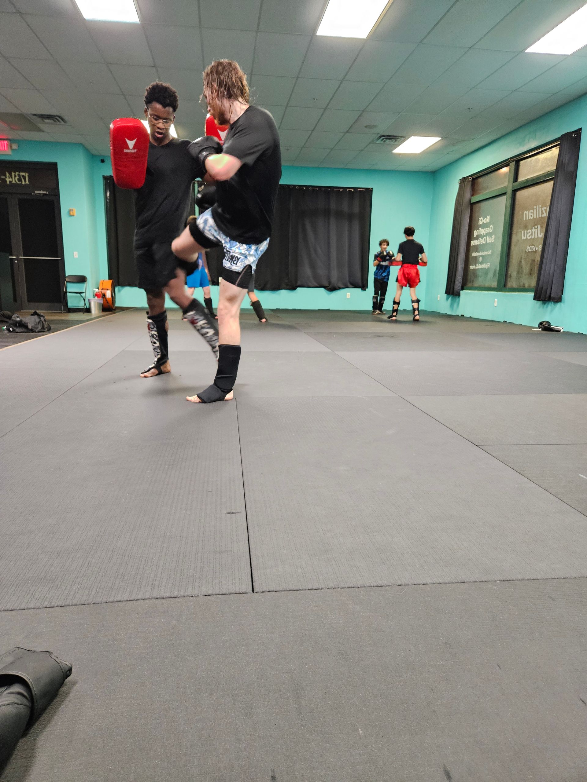 Adults practicing Brazilian Jiu-Jitsu drills at Rip Tide Brazilian Jiu Jitsu in Lewes, DE.