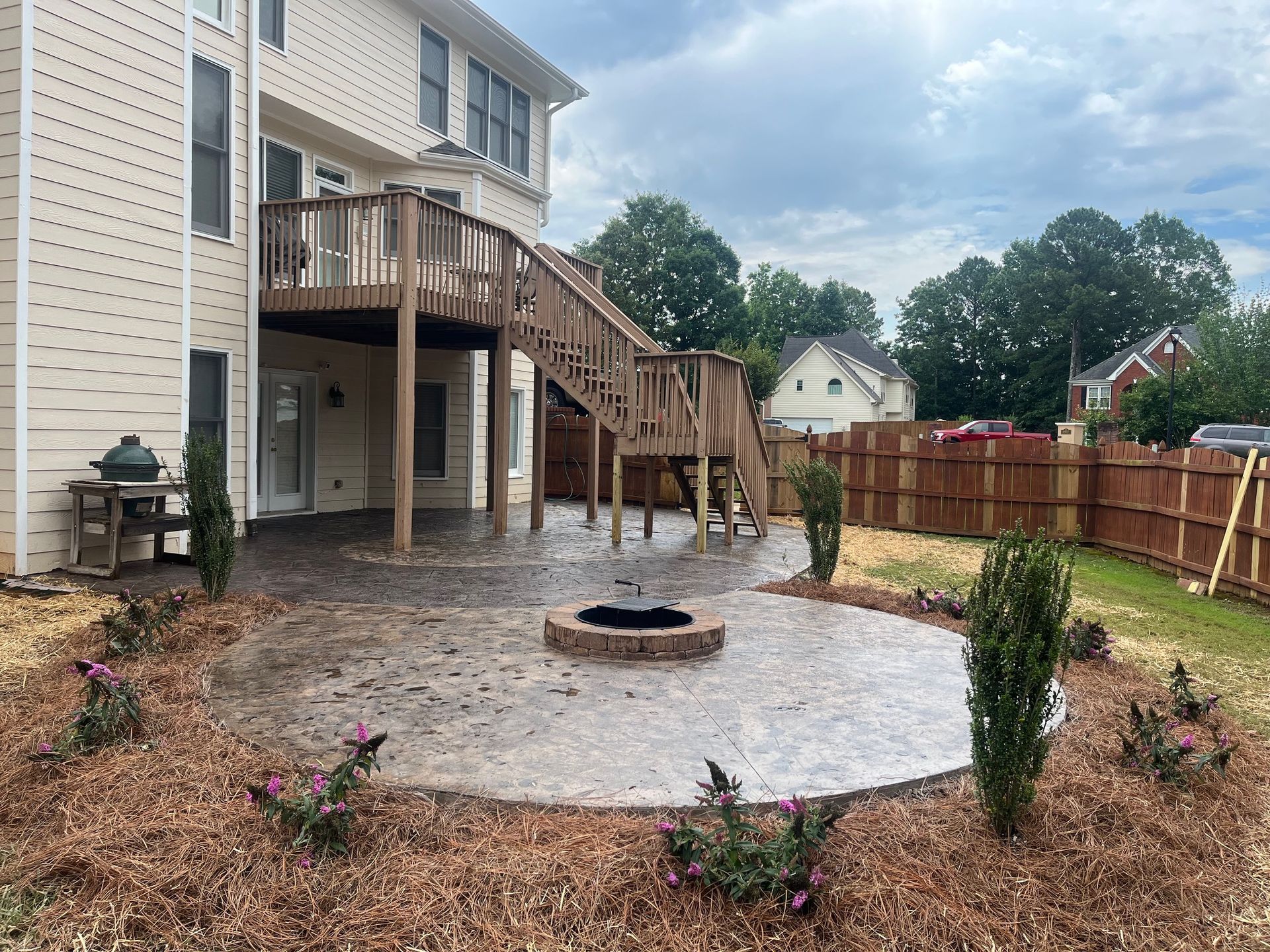 A house with a deck and a fire pit in the backyard.