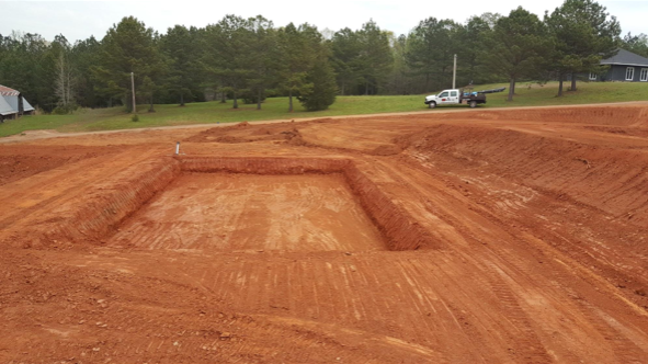 A white truck is parked in the middle of a dirt field