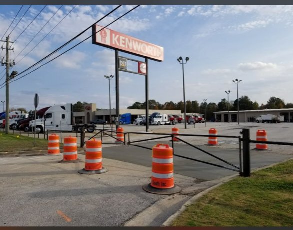 A kenworth sign is above a parking lot