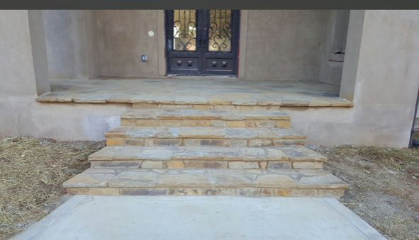 A stone staircase leading up to the front door of a house.