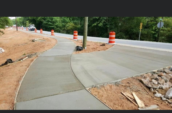 A concrete walkway is being built next to a road.