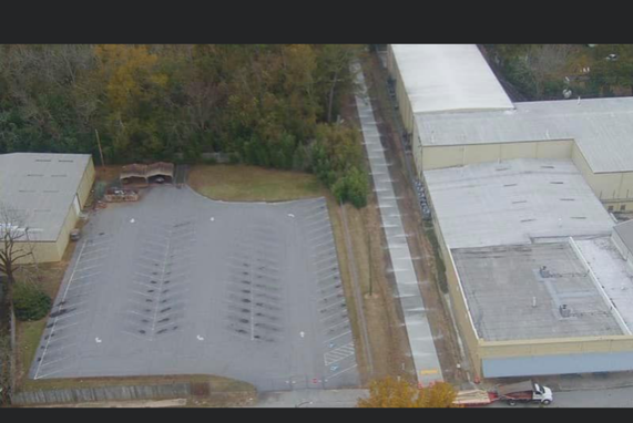 An aerial view of a parking lot surrounded by buildings and trees.