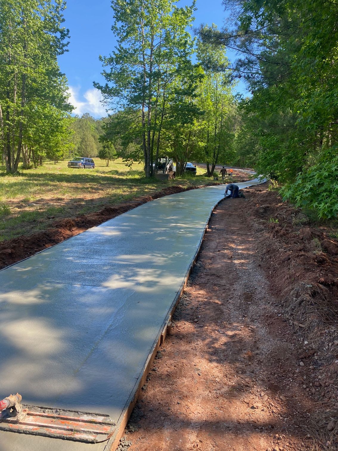 A concrete driveway is being built in the middle of a forest.