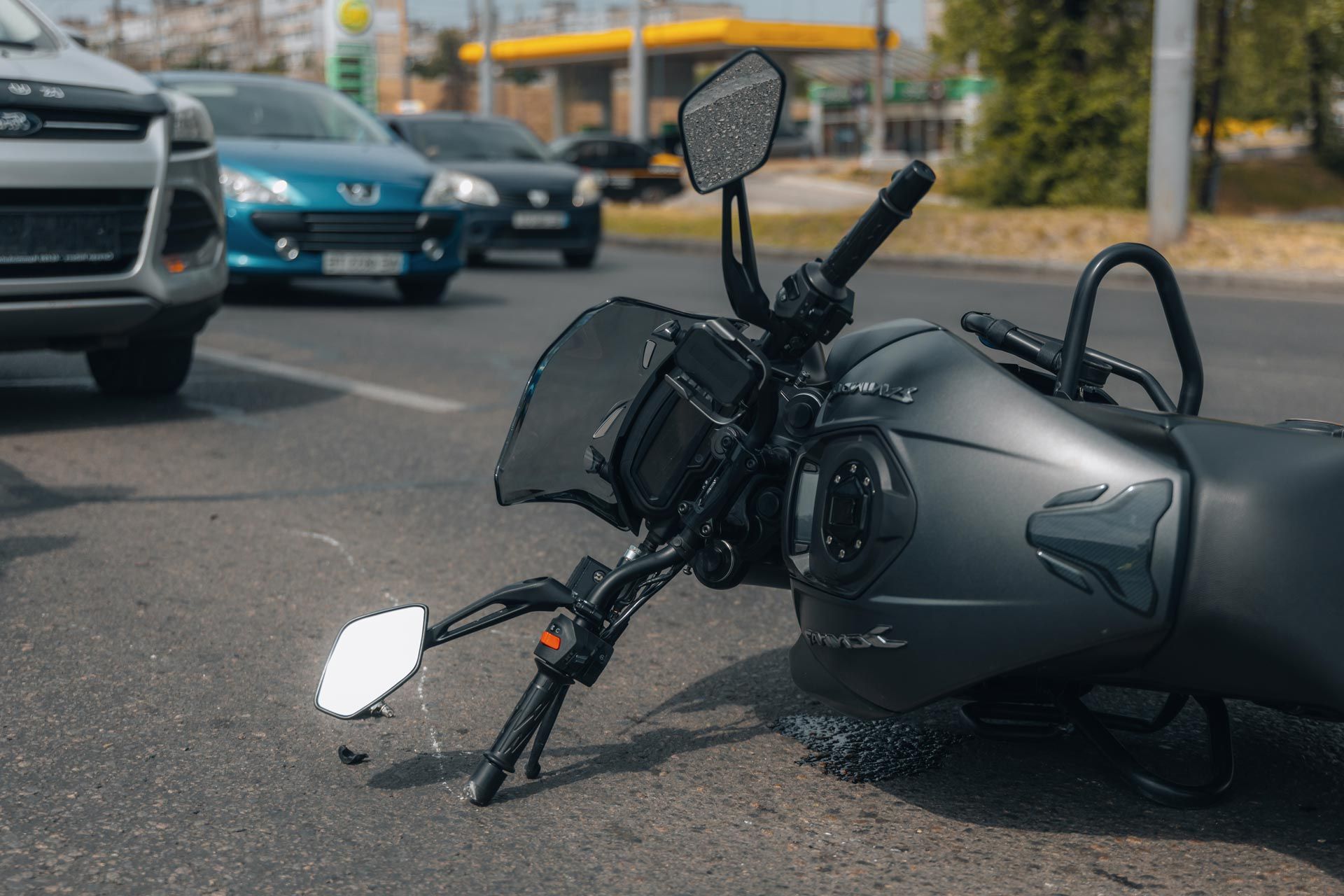 Motorcycle accident with bike lying on roadway amid traffic. Motorcycle accident with bike lying on roadway amid traffic.