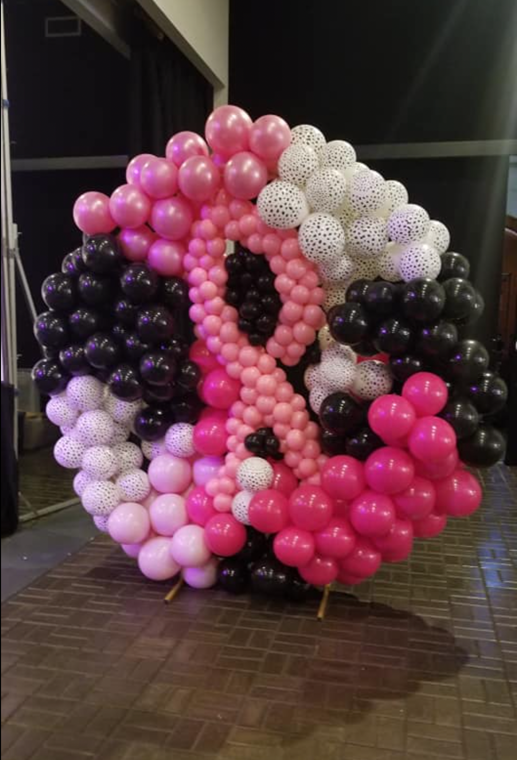 A bunch of pink and black balloons in a circle