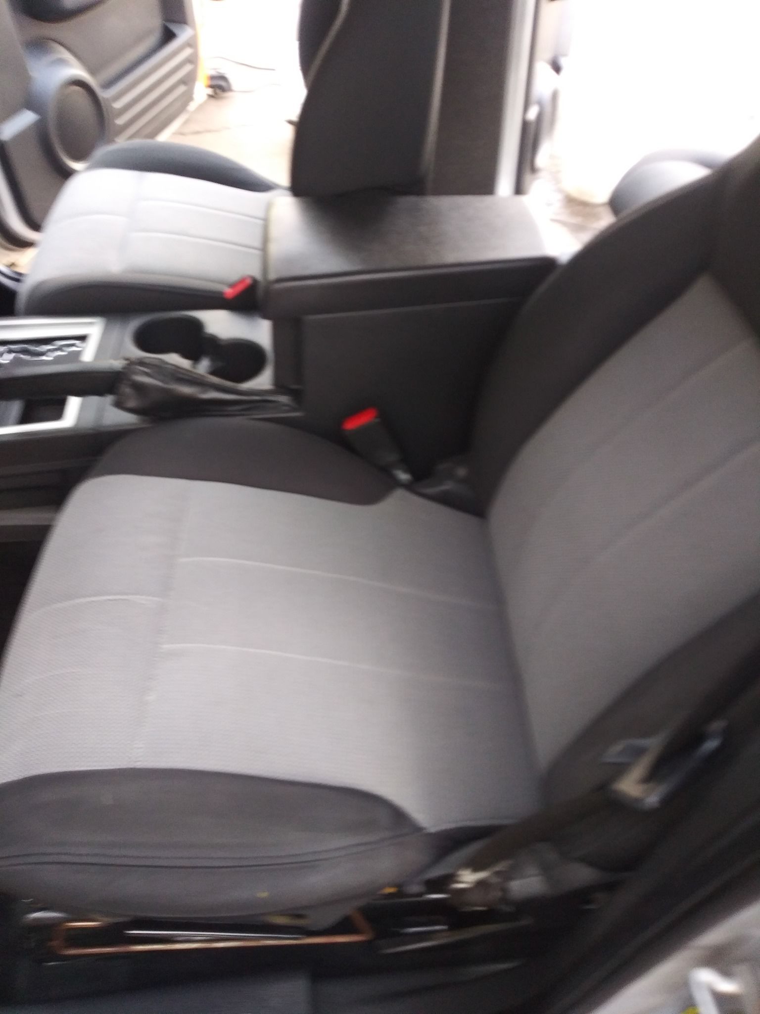 Gray and black car interior with center console and driver's seat.