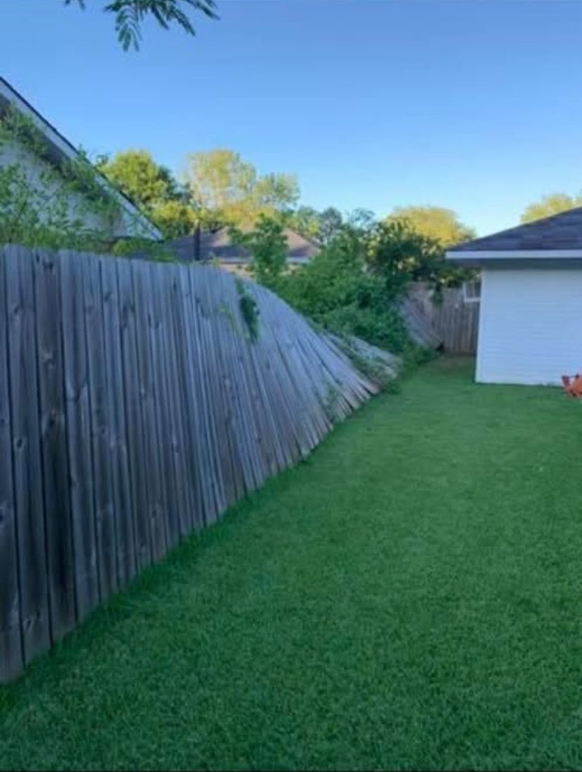 There is a wooden fence in the backyard of a house.