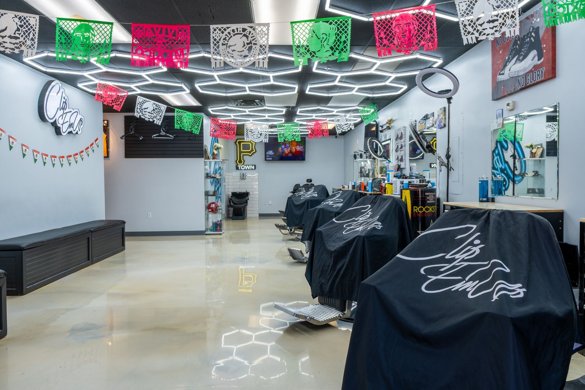 Decorated barber shop interior with black draped chairs and festive red, green, and white ceiling lights