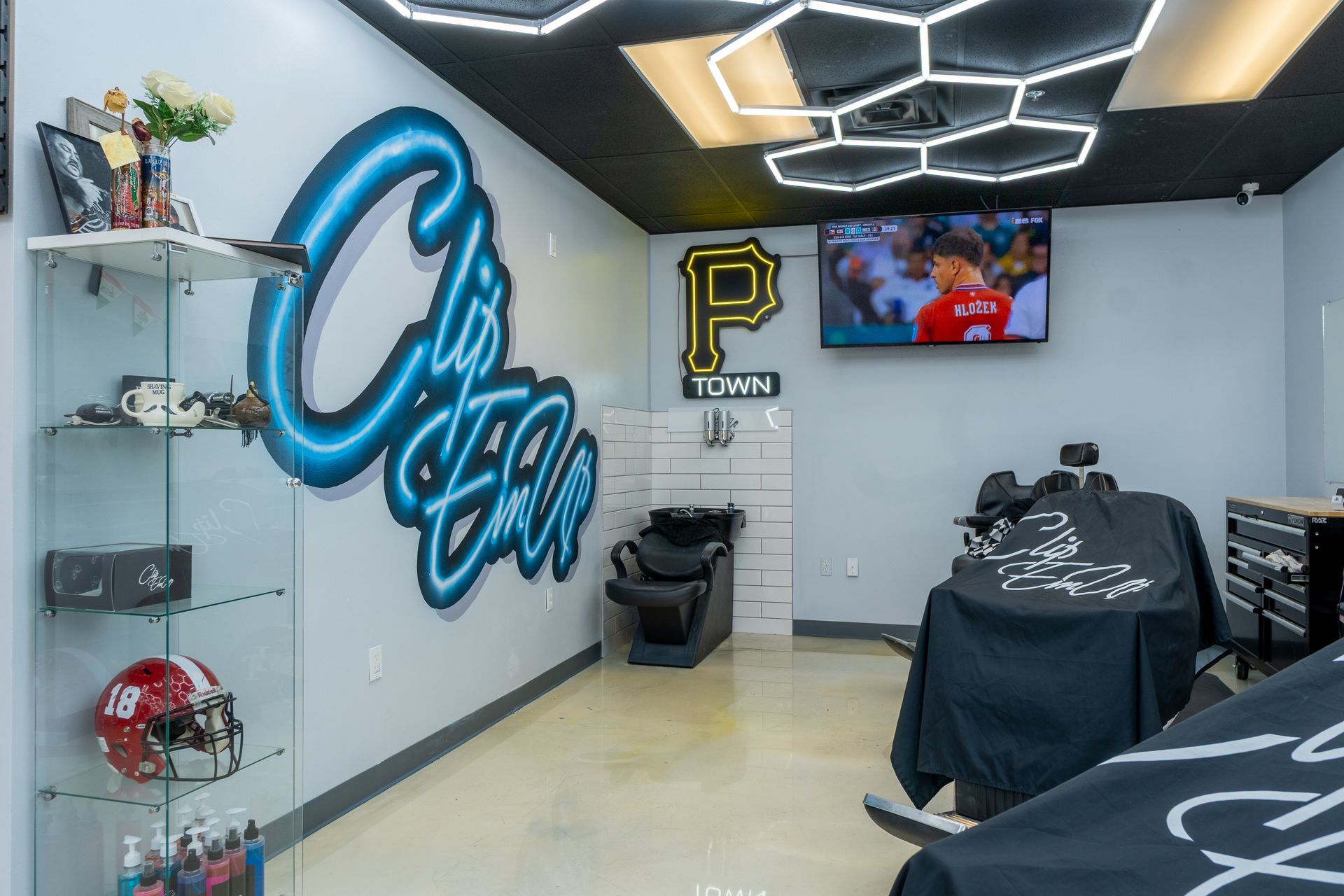 Stylish game room with neon wall art, LED ceiling lights, TV, and gaming chairs