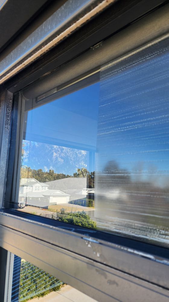 Window View Showing a Clear Sky and Blurry Buildings — Rapid Rinse Solutions in Shepparton, VIC