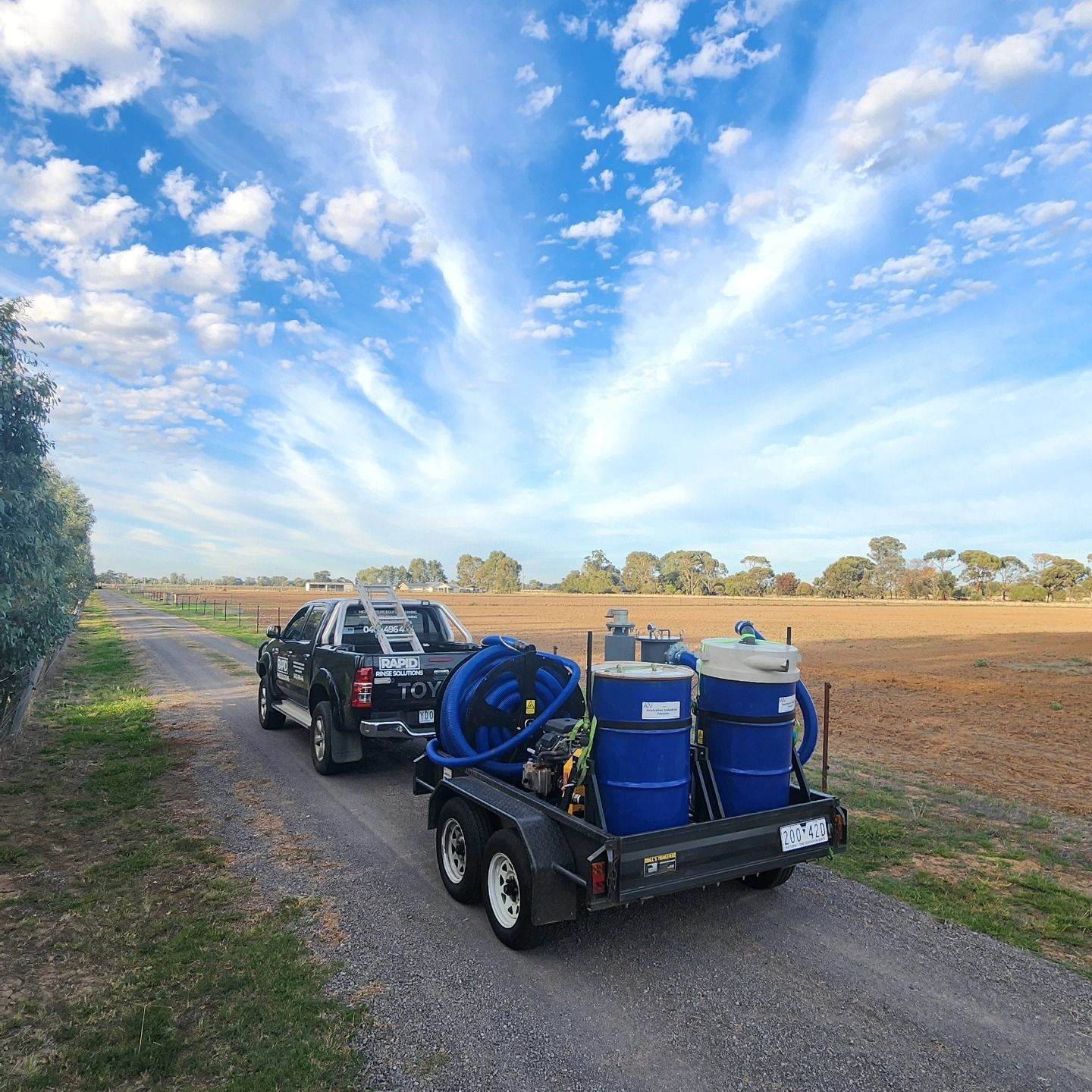 A Person Cleaning Solar Panels With a Long-handled Brush and Water Hose — Rapid Rinse Solutions in Shepparton, VIC