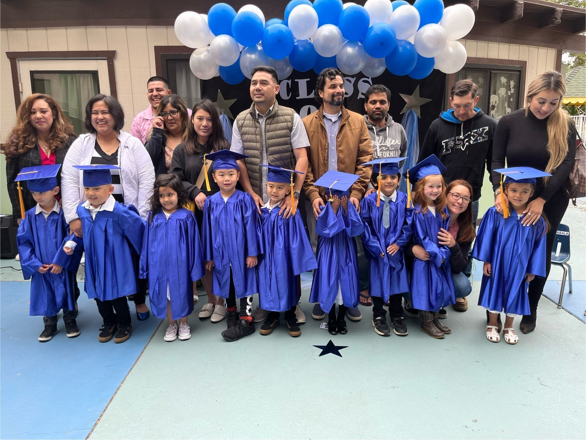 A group of children in graduation caps and gowns are posing for a picture.