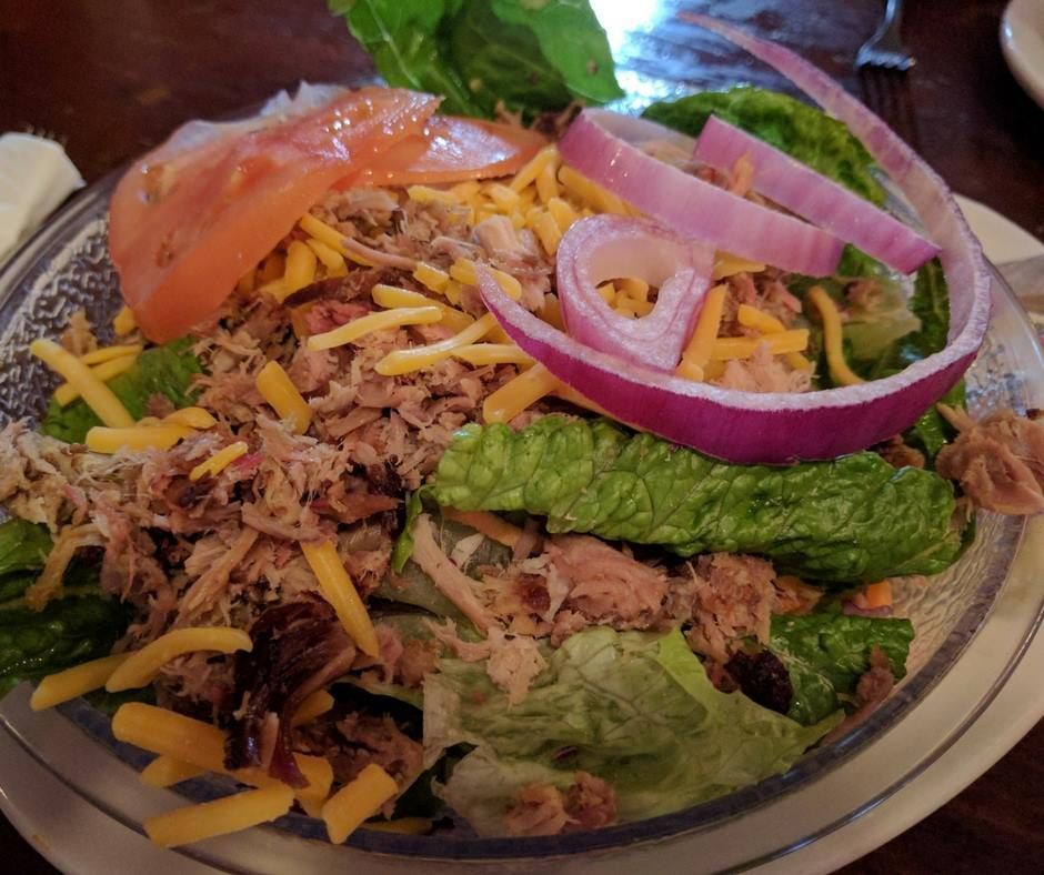 A salad with tuna lettuce cheese and onions on a plate