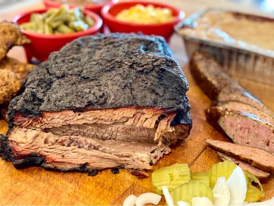 A large piece of meat is sitting on top of a wooden cutting board.