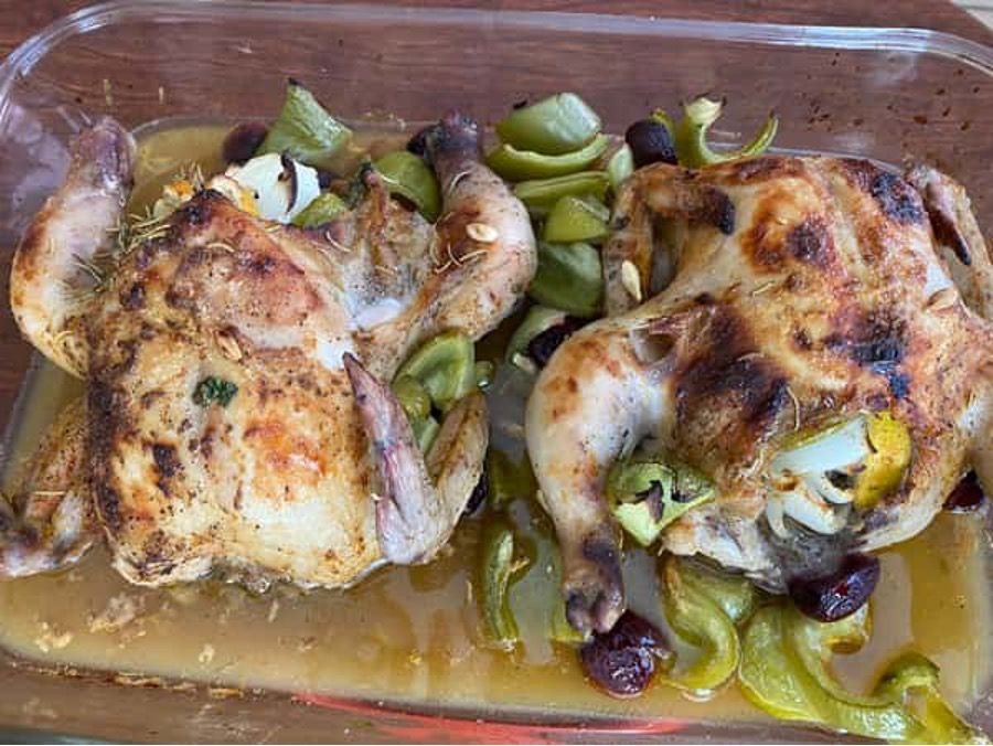 A casserole dish filled with chicken and vegetables on a table.