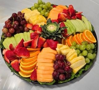 Fruit platter with strawberries, grapes, cantaloupe, pineapple, oranges, and kiwi.