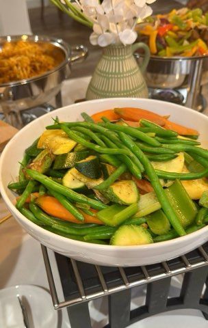 Roasted vegetables in a white bowl: green beans, carrots, zucchini, green peppers.