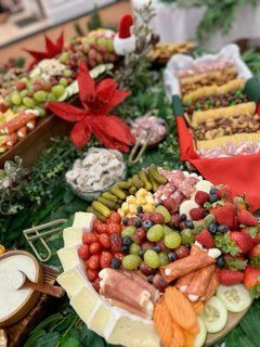 Charcuterie board with cheese, grapes, berries, salami, and Santa hat decoration.