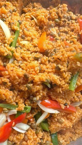 Close-up of a colorful rice dish with vegetables, including red and green bell peppers and white onions.