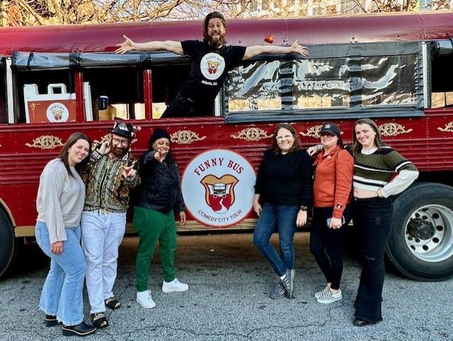 Group of adults at the red Funny Bus before a weekend comedy tour