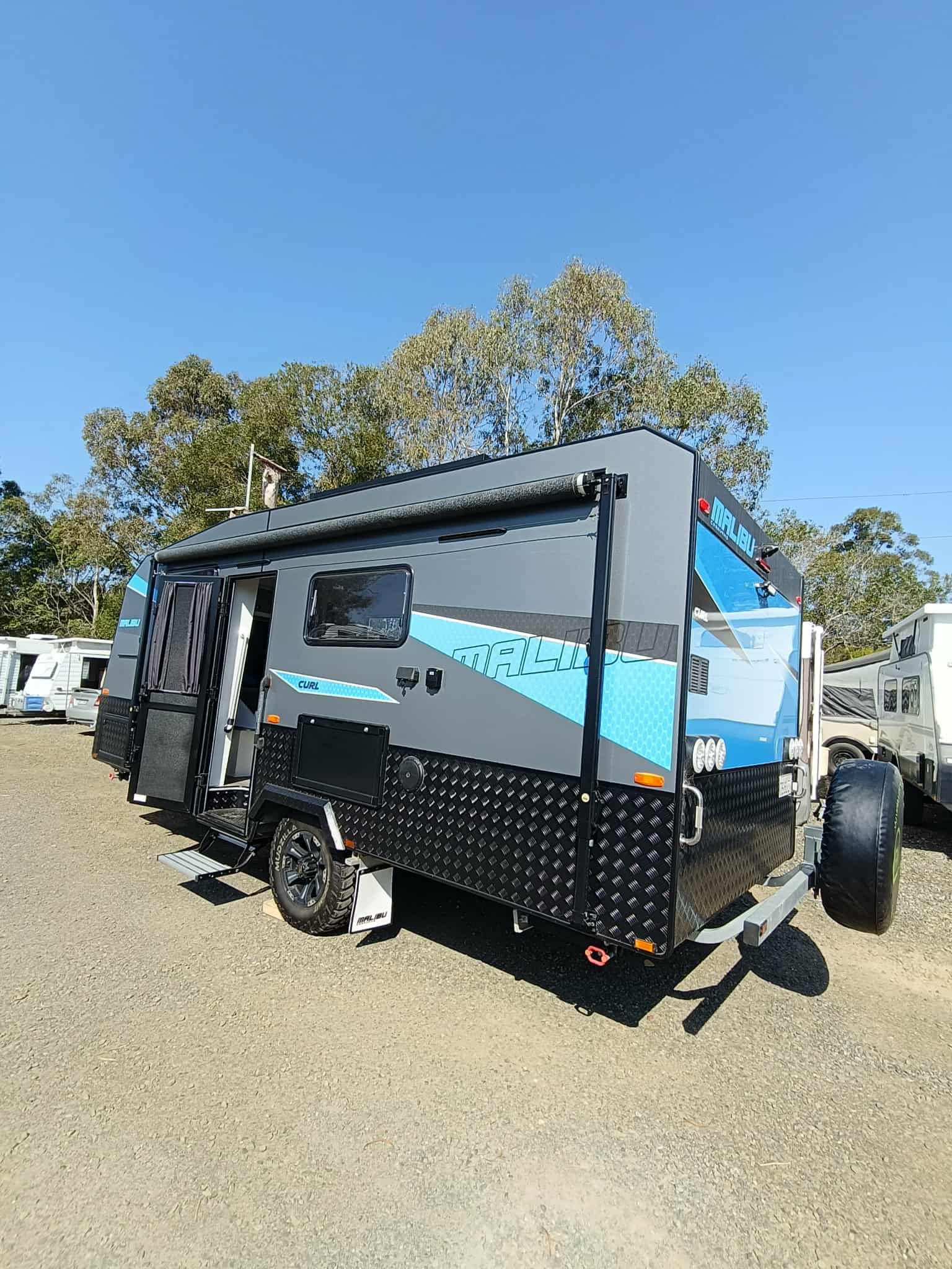 Grey, Black, and Blue Caravan Parked Outdoors on Gravel — Great Lakes Caravans & RV P/L In Hunter Valley, NSW
