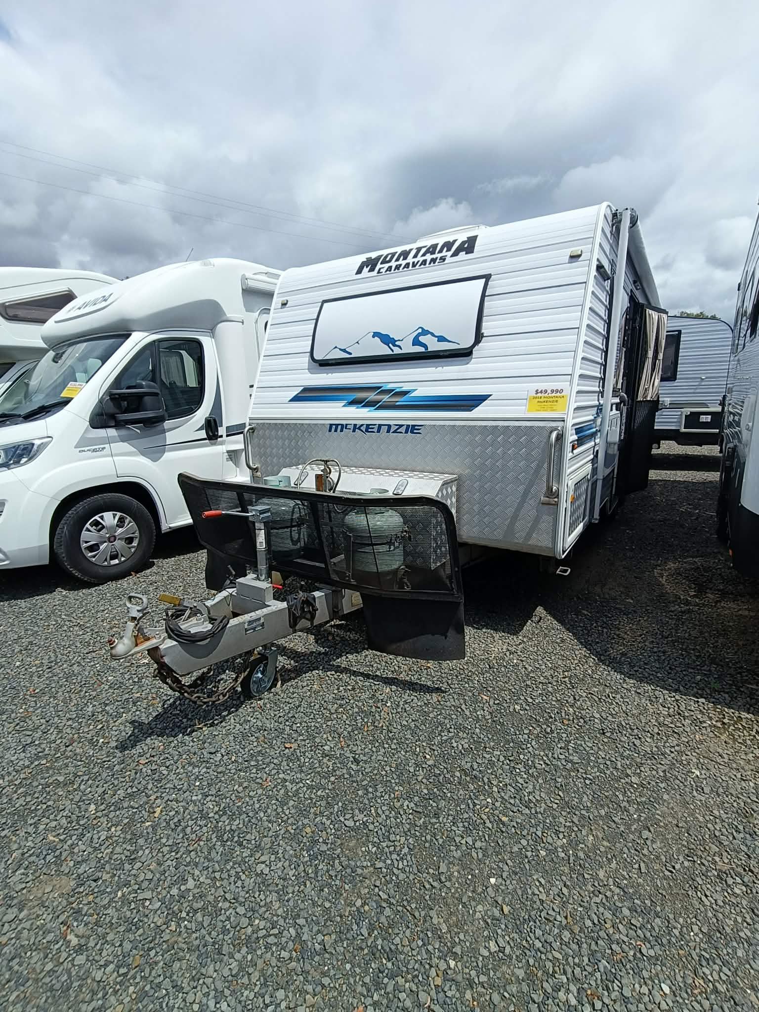White Caravan With Blue Accents Parked on Gravel — Great Lakes Caravans & RV P/L In Nabiac, NSW