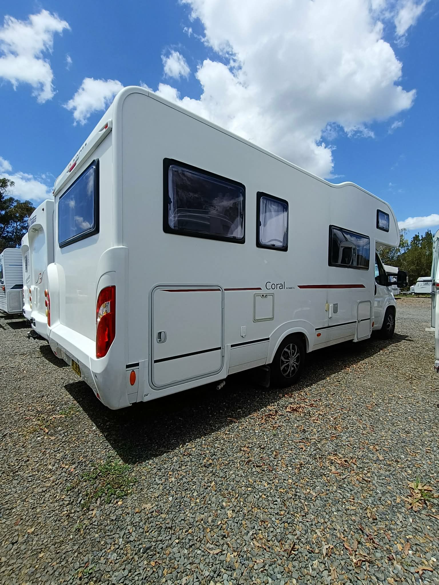 White RV Parked on Gravel Under a Blue Sky — Great Lakes Caravans & RV P/L In Newcastle, NSW