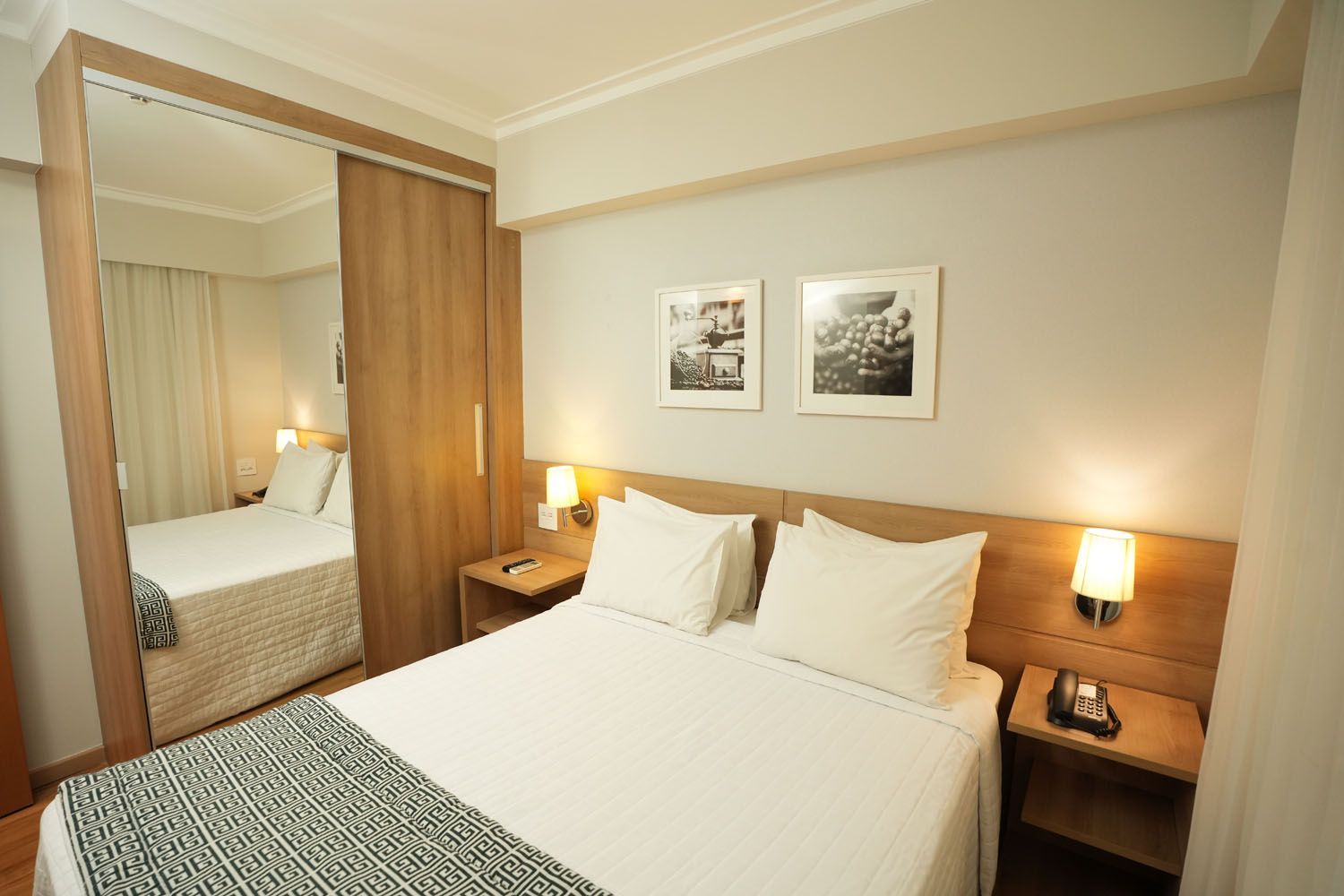Um quarto de hotel com uma cama king size e duas mesas de cabeceira.