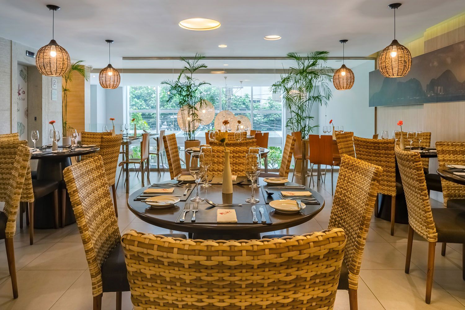 Uma grande sala de jantar com cadeiras e mesas de vime.