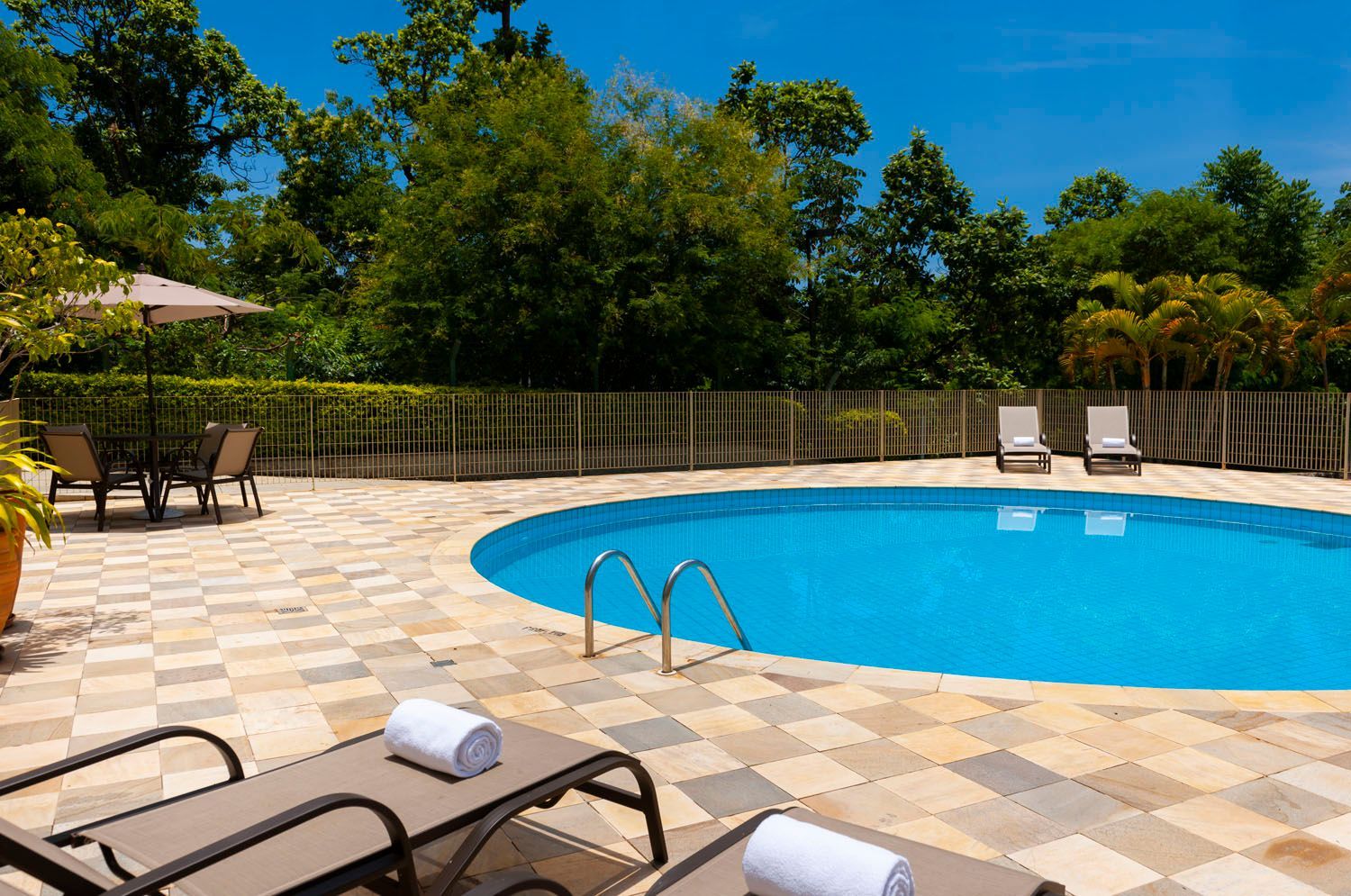 Uma grande piscina com cadeiras e guarda-sóis ao redor