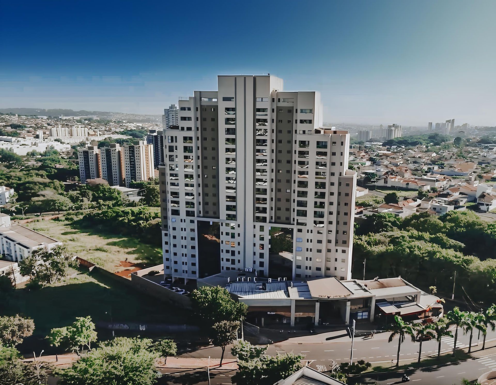 Uma vista aérea de uma cidade com um edifício alto em primeiro plano
