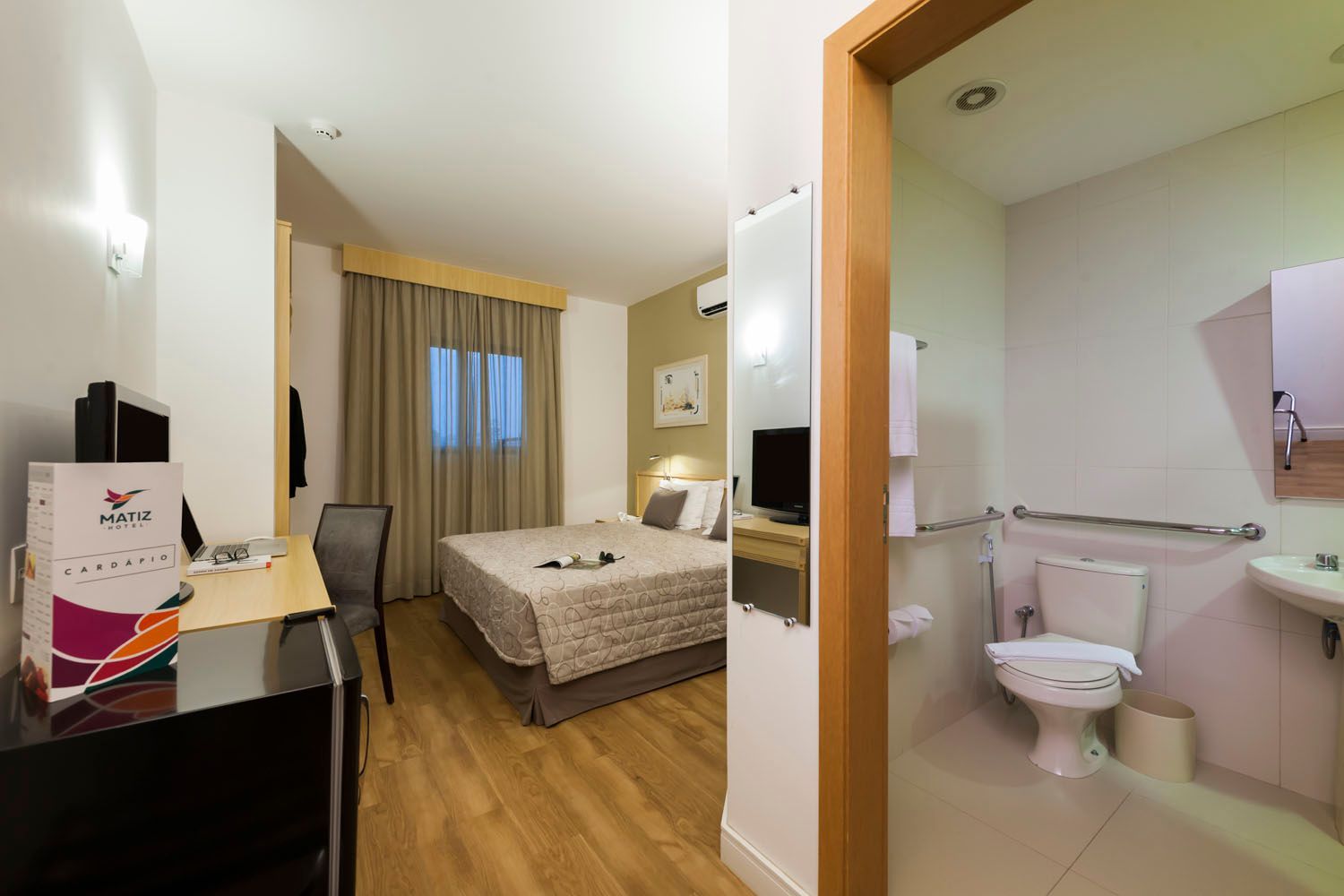 Um quarto de hotel com uma cama king size e um banheiro para deficientes.
