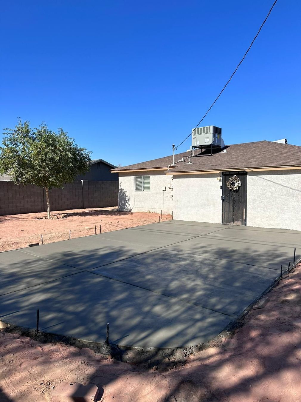 A concrete driveway is being built in front of a house.