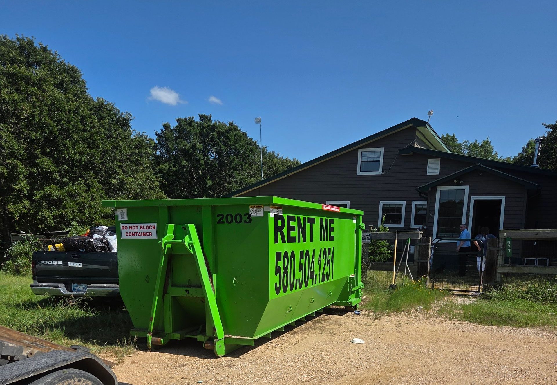 Green dumpster labeled