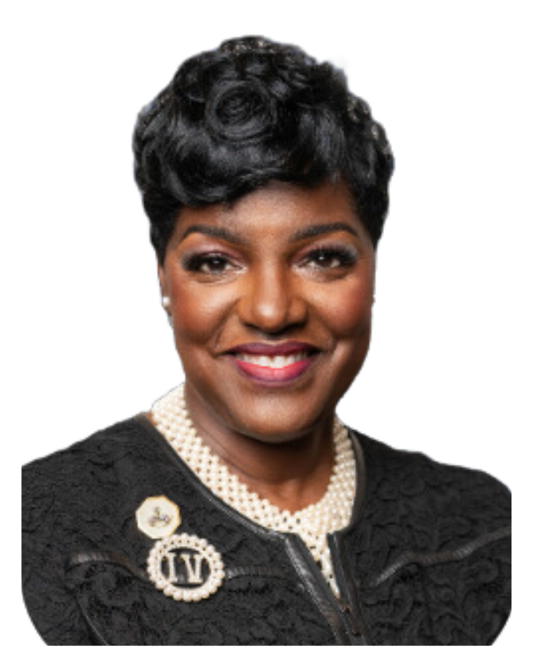A woman wearing a black jacket and pearls is smiling