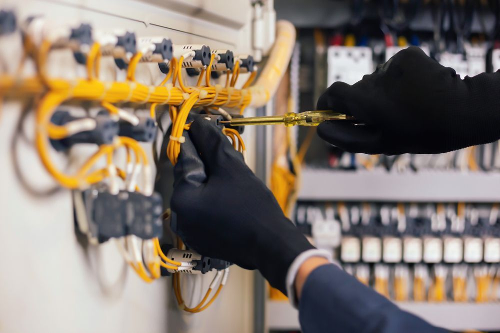 Gloved Hands Working on Yellow Network Cables — Cairns Excel Electrics In Palm Cove, QLD